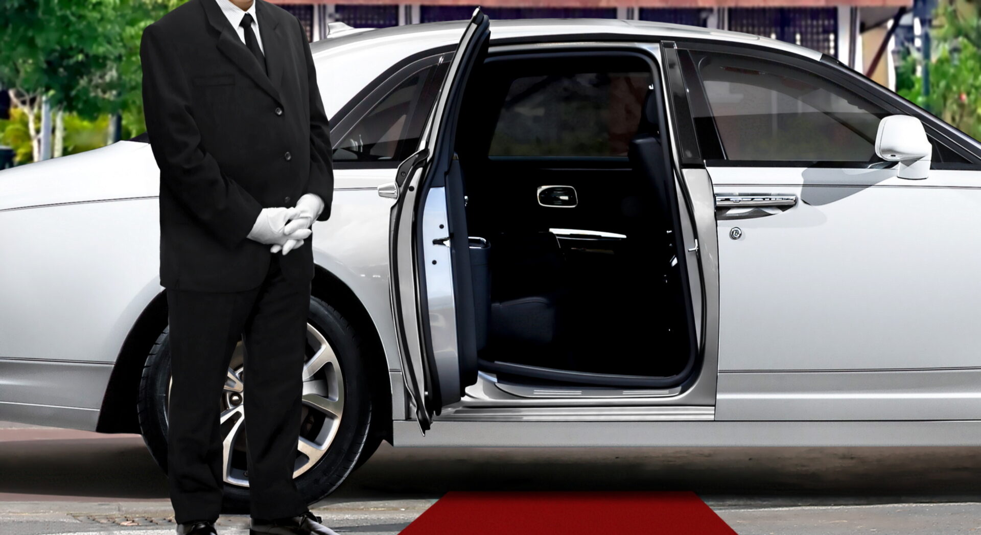 Limo driver standing next to opened car door with red carpet
